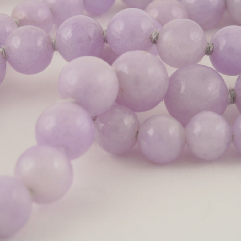 A lavender jadeite/jade necklace with an 18 karat gold and diamond clasp. The necklace has 93 natural jadeite lavender beads, measuring 12.5 mm. x  6.1 mm.

Circa 1980. 

Asian Gemological Institute and Laboratory Limited Certificate No. J-63433