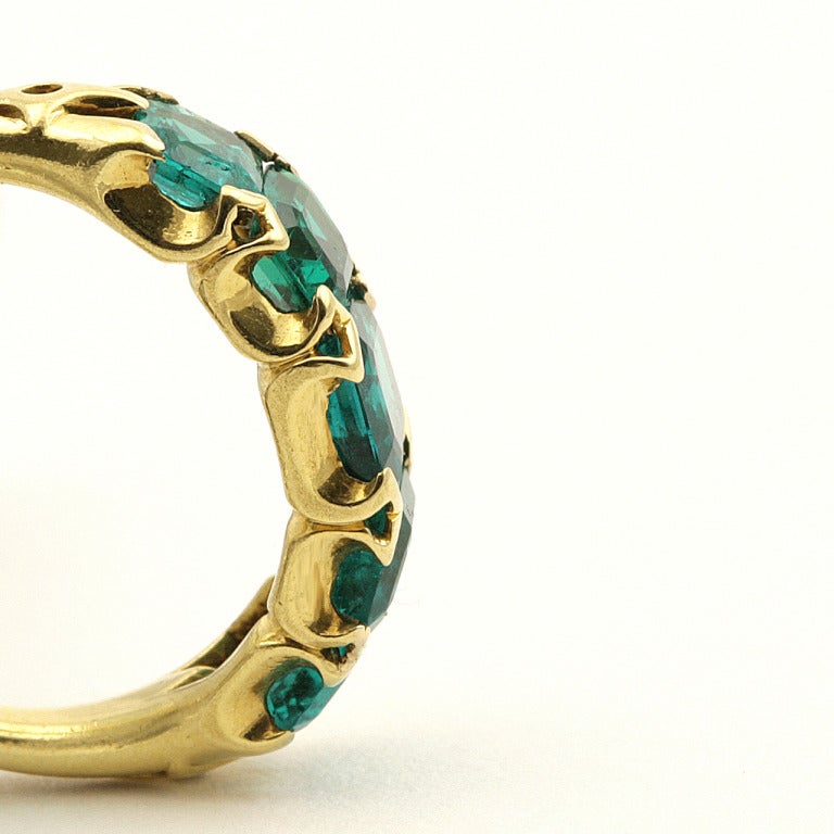 An English Antique 18 karat gold ring with emeralds. The ring has 5 graduated rectangular-cut emeralds with an approximate total weight of 2.65 carats, mounted in a deeply scooped gallery ring. (MG #15474)

Size: 5; this ring can be
