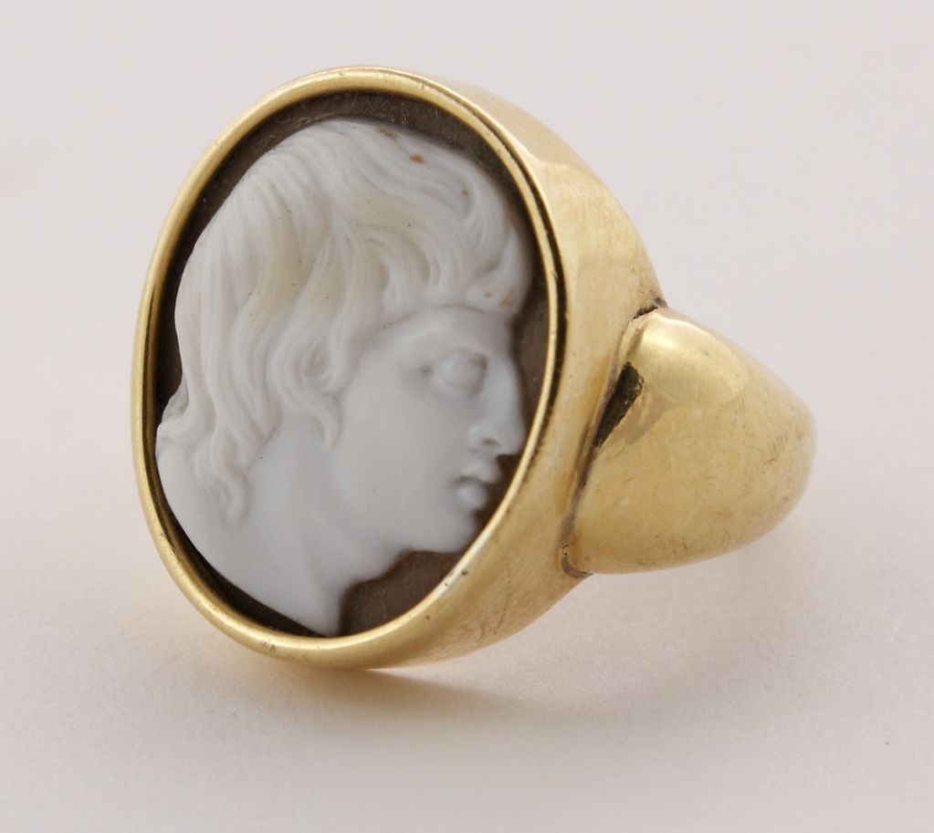 Cameo Ring Depicting Alexander the Great. Florence, late 16-early 17th century White and brown Sardonyx. 19 mm. Yellow gold modern setting Fine and rare cameo with an unusual depiction of Alexander facing left. <br />
The size is 7