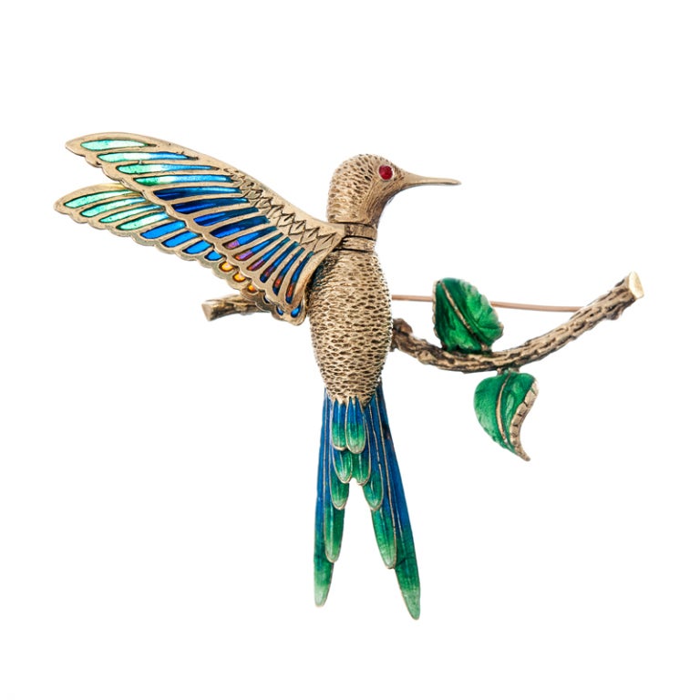 A gorgeous rendition of a sweet and intriguing organic theme... This hummingbird has movable wings and head and is graced with incredibly fine enamel detail. Perched on a curved bracnch, with extended wings, his position can be adjusted to mimmic
