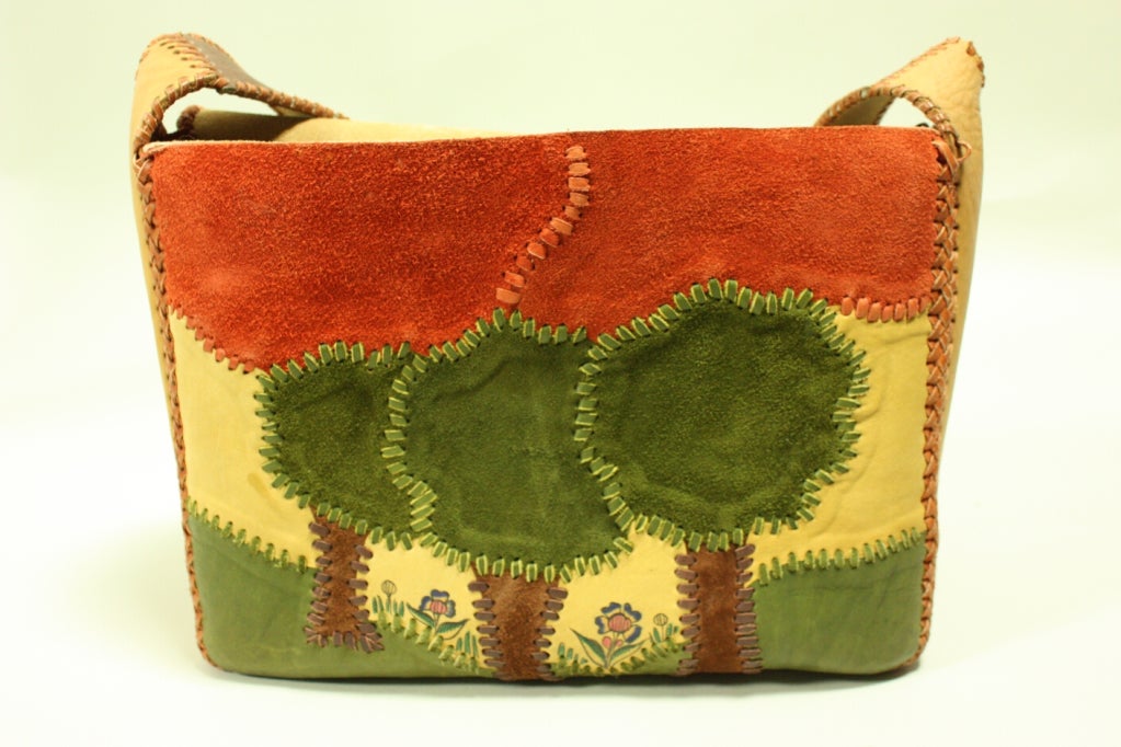Vintage handbag from Char dates to the 1970's and is made of dyed patches of leather and suede that are whipstitched together.  It features two large leather pockets that extend out from the bag with fold over closures.  Interior side pocket. 