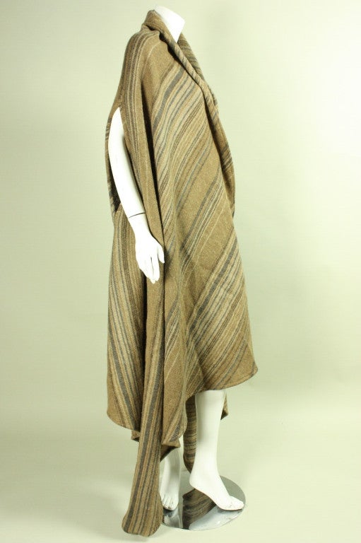 Vintage cape from Issey Miyake dates to the 1980's and is made of striped tan wool.  It has a relaxed shape with two openings for the arms at the elbows.  Asymmetrical back and side seam.  Unlined.  No closures.

Open size.