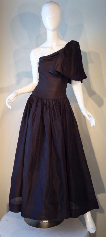A fine Chanel tea gown. Ethereal and lightweight black silk gazar fabric swathed tightly for a single shoulder bodice and dropped waist. Fully lined floor length skirt features a gathered waist. Matching pleated panel adorns shoulder. A charming