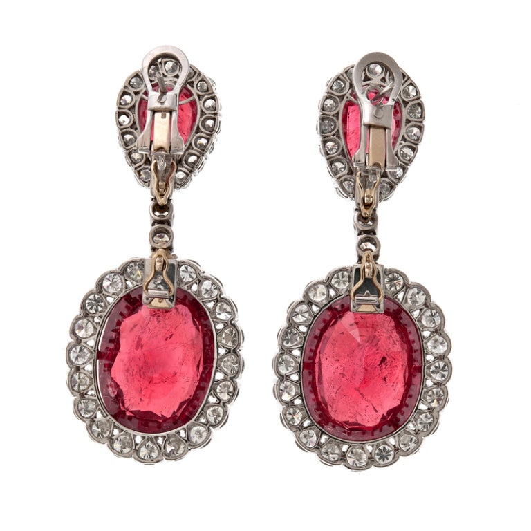 An awe inspiring pair of ruby and diamond substantial drop earrings. The two oval shaped rubies weigh 50 carats between the two, a solid and deep red hue. The pear shaped rubies which detach to wear separately, weigh 9 carats in total. An additional
