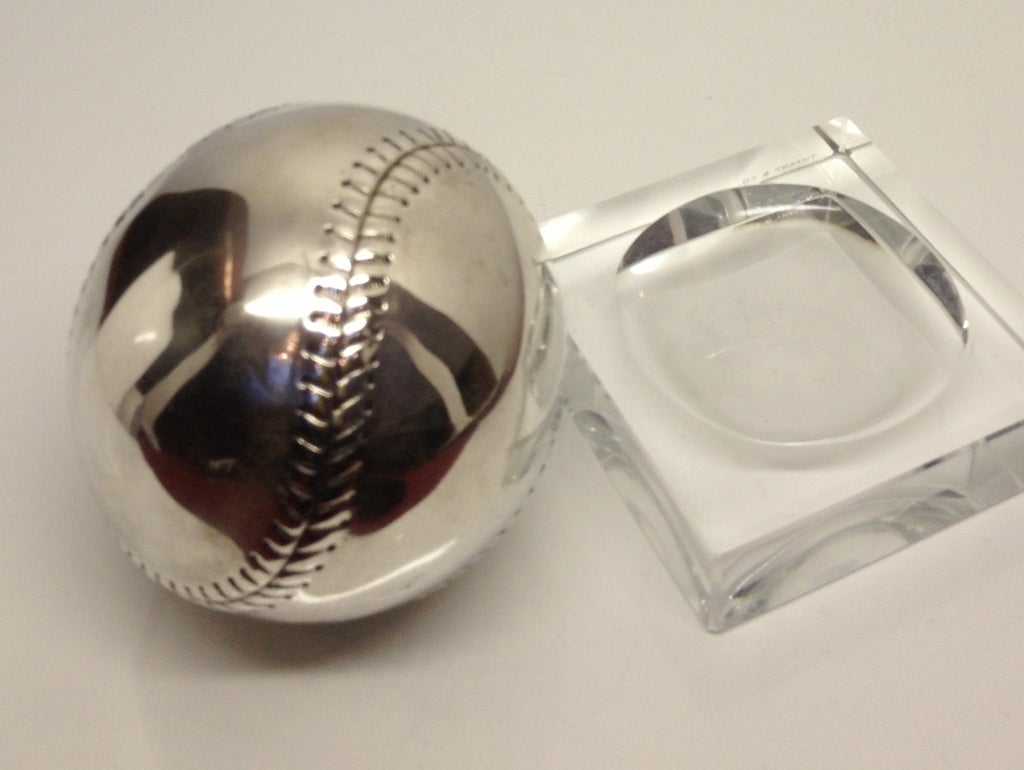 This sterling silver baseball sits on a glass holder just waiting to be picked up and handled as it has great tactile qualities.  Its size is that of a real baseball!.