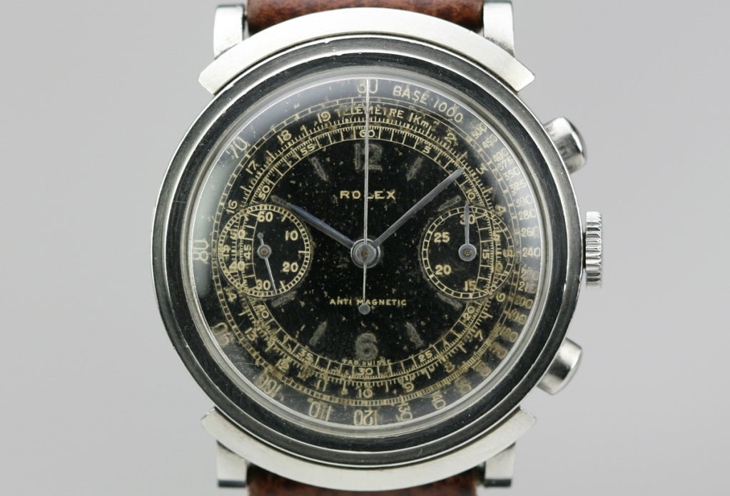 This is an early and rare Rolex hooded lug chronograph wristwatch, reference 2916, which almost never comes up for sale. This Rolex has an original black gilt dial with seconds and telemetre tracks, needle hands, two small black registers, oval pump