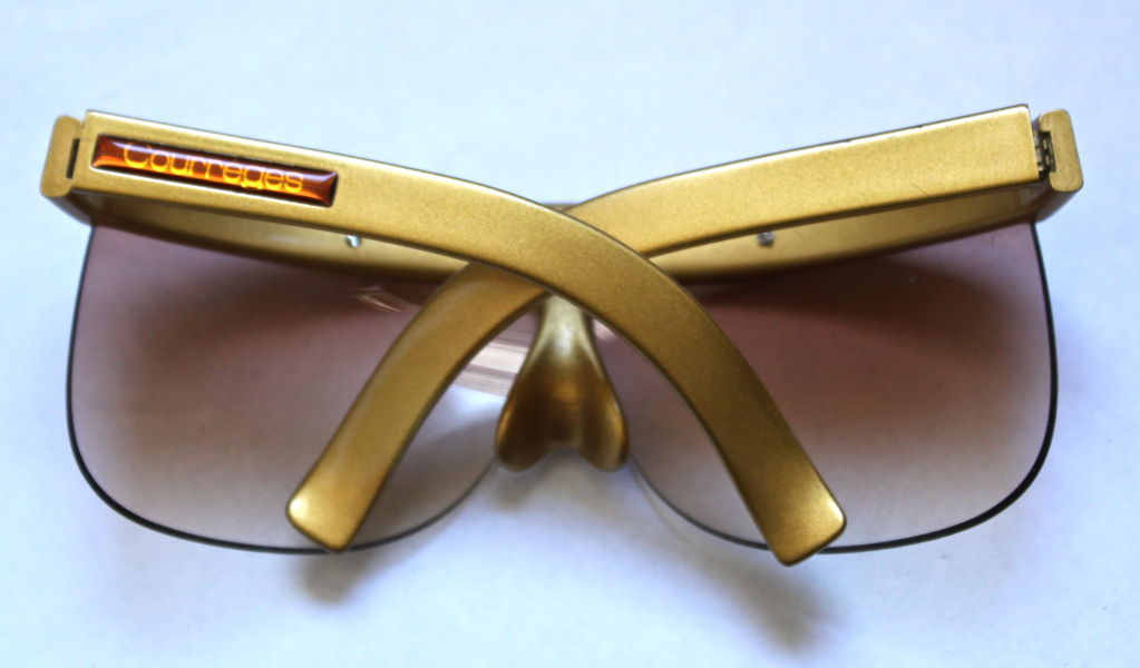 Very unusual futuristic gold plastic shield sunglasses from Courreges dating to the 1970's. Sunglasses measure approximately 6