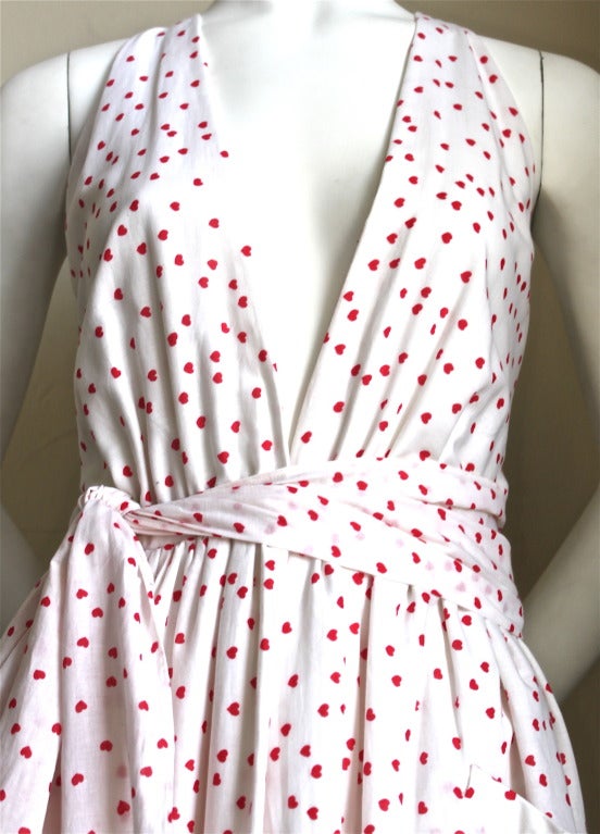 White cotton wrap dress with red hearts with fabric belt from Halston dating to 1978. Fits a size 2 or 4. Waist is 25