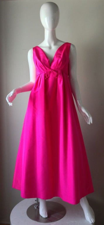 A fine vintage Helen Rose gown. Intensively vivid pink super fine silk faille item features a empire waistline and full floor length sculpted skirt. Item fully lined and zips up back.