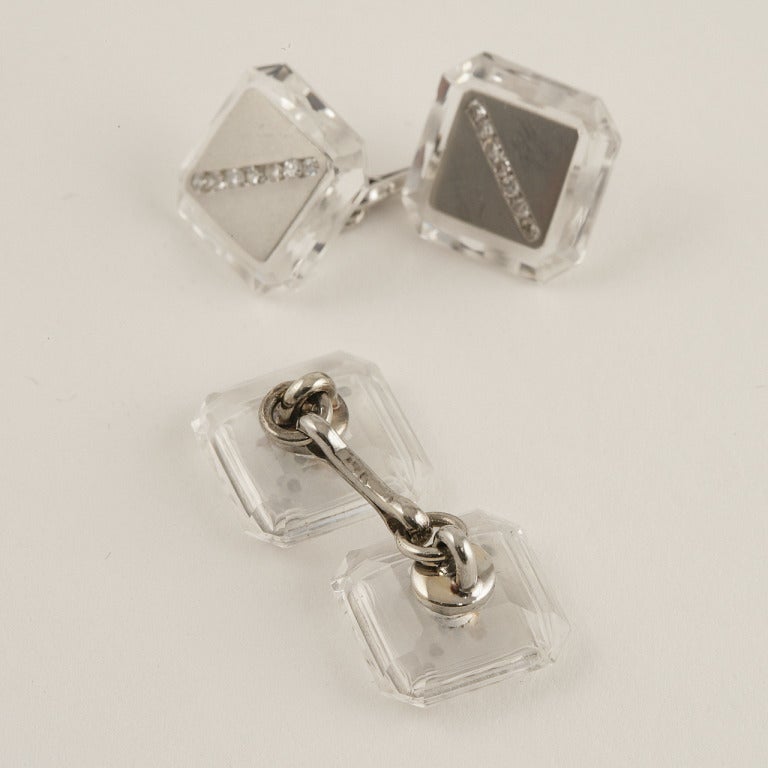 An American Art Deco 14 karat gold, platinum and diamond 9 piece dress set. Each piece centers on a diagonal stripe of diamonds that are set into a platinum table which is mounted on a faceted rock crystal square. The pair of cufflinks. shirt and