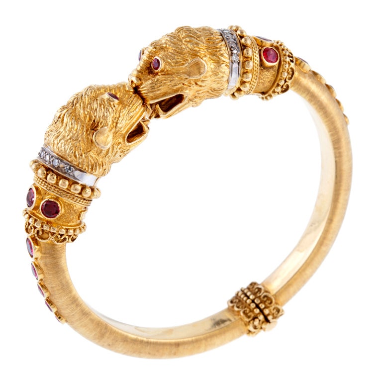 Etruscan revival style hinged clamper style bracelet with tons of detailed gold work, granulation and texture. 18 karat gold is artfully sculpted into the heads of beasts. They are wearing platinum diamond-studed collars and are embellished with