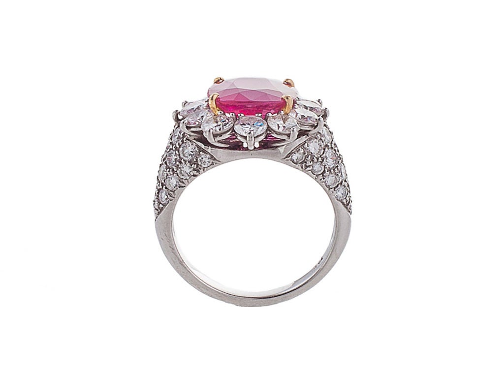 The ring centers one four prong-set mixed cushion-cut/brilliant crown Burmese ruby surrounded by 12 prong-set round brilliant-cut diamonds, the shoulders pave-set with 38 round brilliant-cut diamonds. Total diamond weight is approximately 3.30