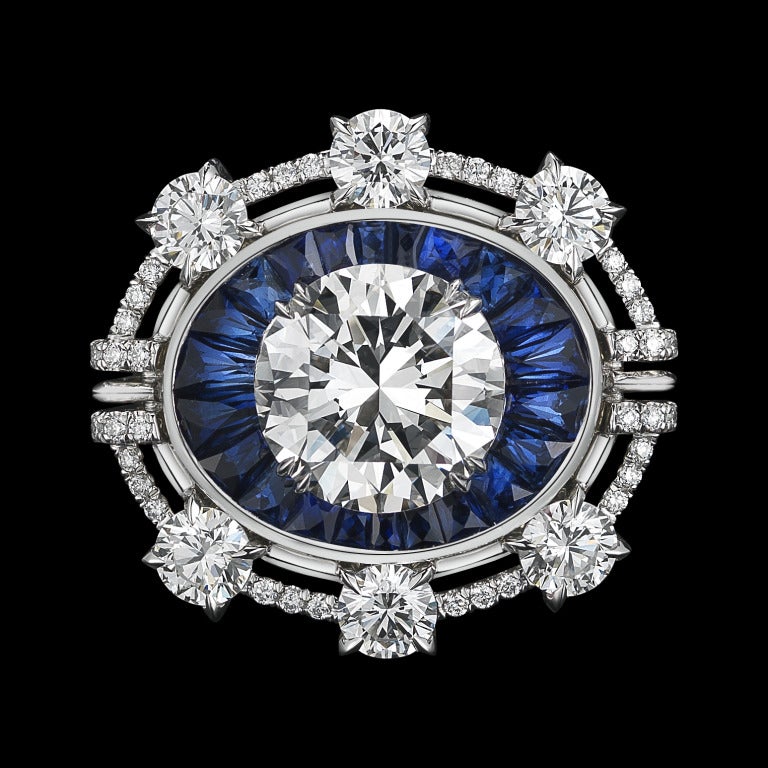 A one-of-a-kind Diamond ring comprised of 22 blue Sapphire Trapezoids totaling 2.80 carat weight and a 4.02 carat Brilliant-Cut Diamond floating in the center, surrounded by six 4mm round Diamonds, enhanced by Alexandra Mor signature details of 1mm