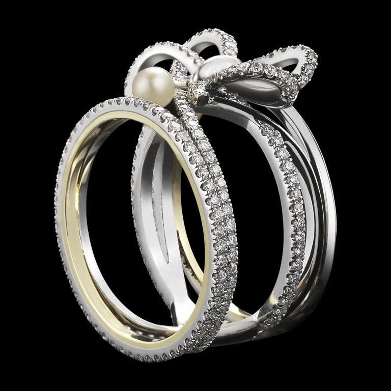 A contemporary Diamond Bow and Pearl ring set with Alexandra Mor signature details of 1mm knife-edged wire and 1mm floating Diamond melee weighing a total of 1.13 Cts. Ring size 7.75.