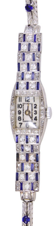 Elegant lady's watch set in platinum. Punctuated by diamonds and sapphires in Art Deco pattern that extends across the entire top of the wrist. Mechanical movement. Distintive and chic.
8 1/2