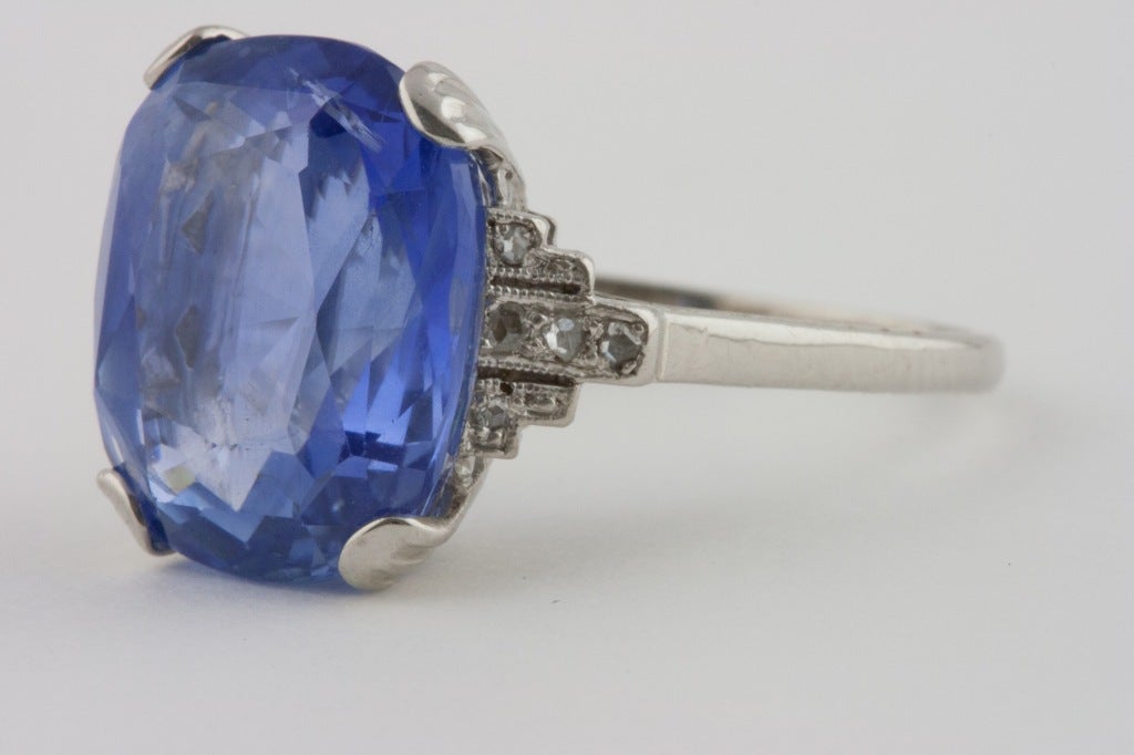 Lovely 11 carat royal blue sapphire, set in a platinum Art Deco ring accented by diamonds. The luxuriously blue stone has been certified by the GIA. The certificate states that the sapphire is from Ceylon with no indications of heat treatment.