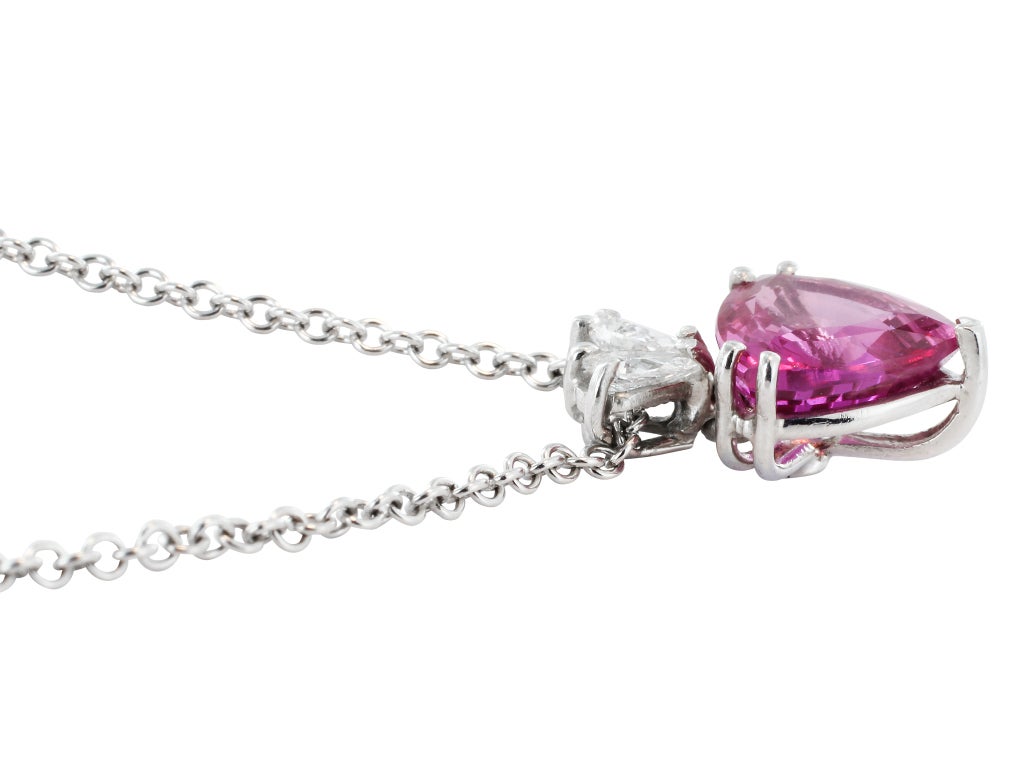 Platinum pendant consisting of 1 triangular brilliant cut pink sapphire weighing 3.25 carats set with 2 pear shape diamond having a total weight of .30 carats.