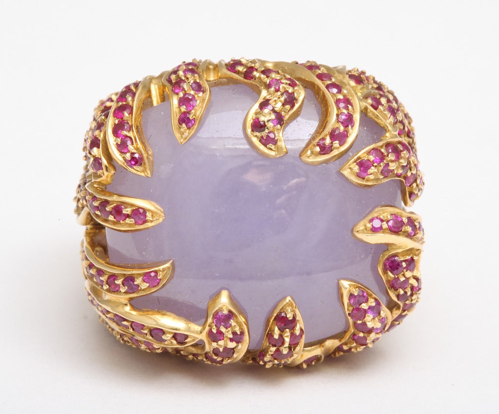 An absolutely unique ring- you will never see another one.  Delicately caged within blazing ruby flames, this fine lavender jade cabochon is a gem quality rarely found.  While jade is often viewed as a connoisseurs stone, the bright violet color,