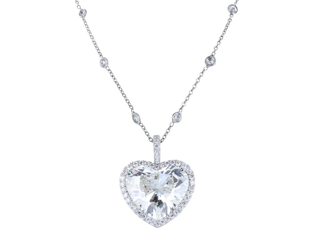 Custom made platinum pendant consisting of one heart shape diamond weighing 8.82 carats, measuring approximately 15.19 x 13.91 x 7.38 mm and having an approximate color and clarity of J/SI1-SI2. The center stone accented with 43 pave set full cut