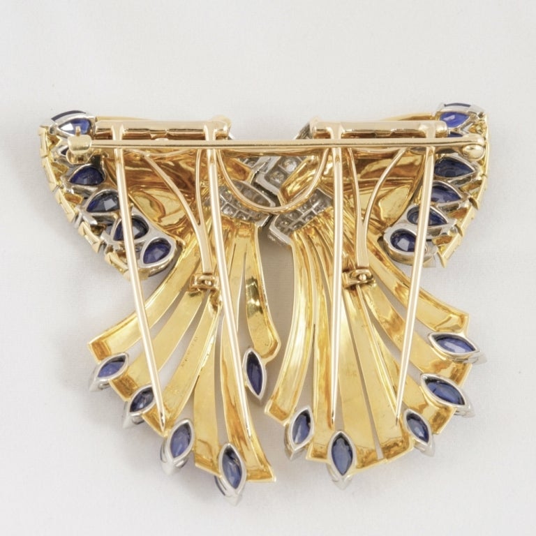 An American Retro 18 karat gold and platinum pair of detachable double clips with diamonds, yellow and blue sapphires by Oscar Heyman. The double clips have 33 round-cut diamonds with an approximate total weight of 1. 90 carats, 10 triangle cut