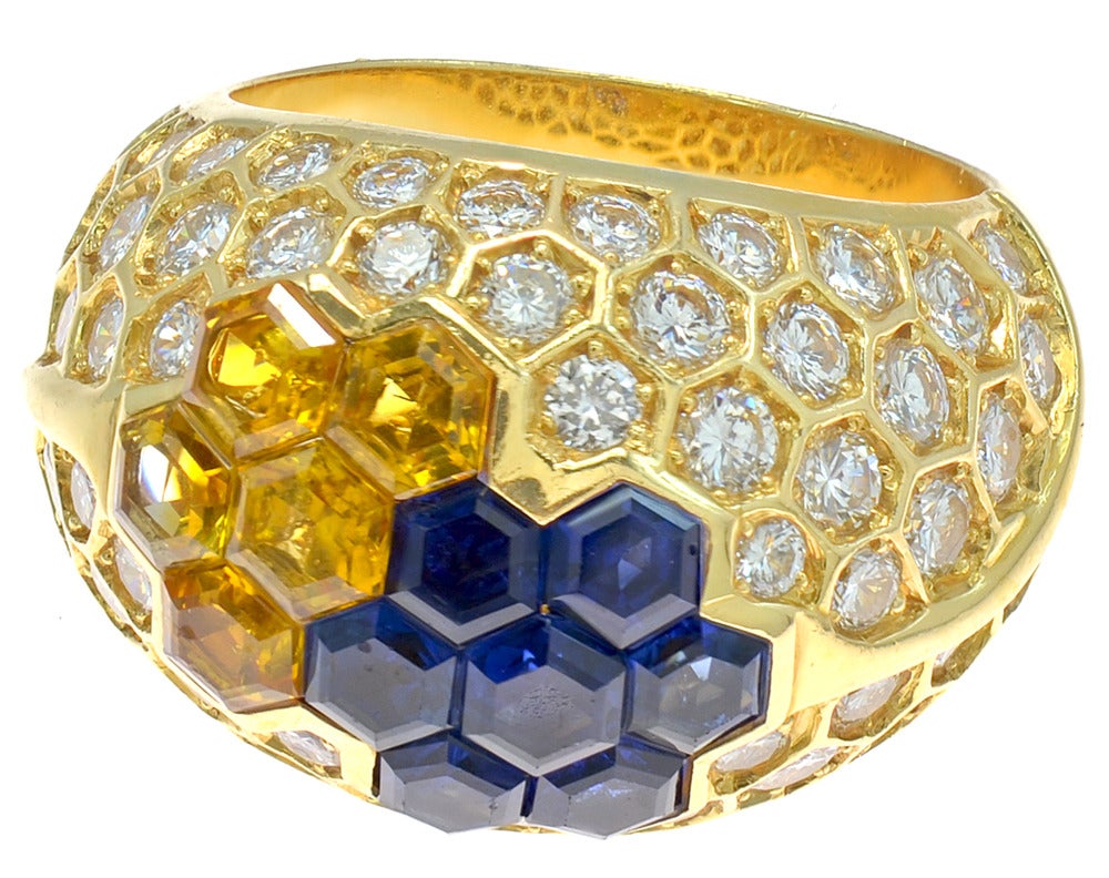A chic Diamond, Blue & Yellow SapphireFrench Dome ring set in 18 karat Gold. This ring is embedded with approximately 3.60 carats of high quality round diamonds. This ring centers octagonal cut Blue & Yellow Sapphires which displays a geometric
