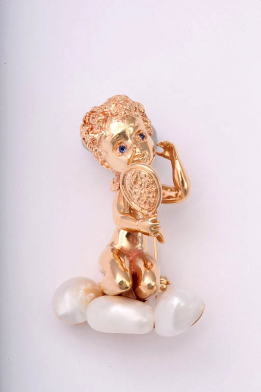 This brooch is a great example of Ruser's children of the week line. This child has sapphire eyes and is looking into a mirror while kneeling on pearls.  It is signed on the back along with the Monday's Child sentence from the poem. 