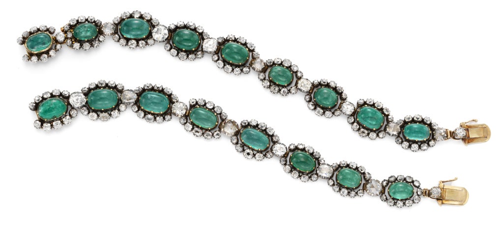 An antique emerald and diamond necklace, designed as a series of sixteen oval cabochon emerald and old mine cut diamond clusters and diamond collet intersections mounted in silver and gold, detachable to form two bracelets and with additions single