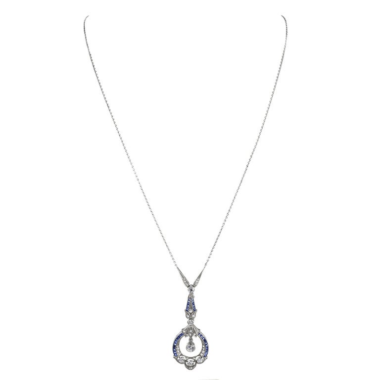 Platinum very fine classical art deco pendant with French cut sapphires and old European cut diamonds. A brilliant mix of feminine finery and substance, this piece drops 1.75 inches and is set on a fixed 15 inch platinum chain. The top of the