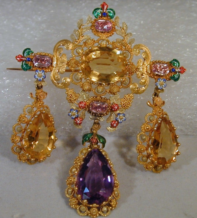 This ultimate brooch in the girandole style incorporates the use of two-color 15K gold set with amethysts and citrines and embellished with enameling to enhance a design of oak leaves, grapes, flowers and berries. Dating to the 1860's it is the best