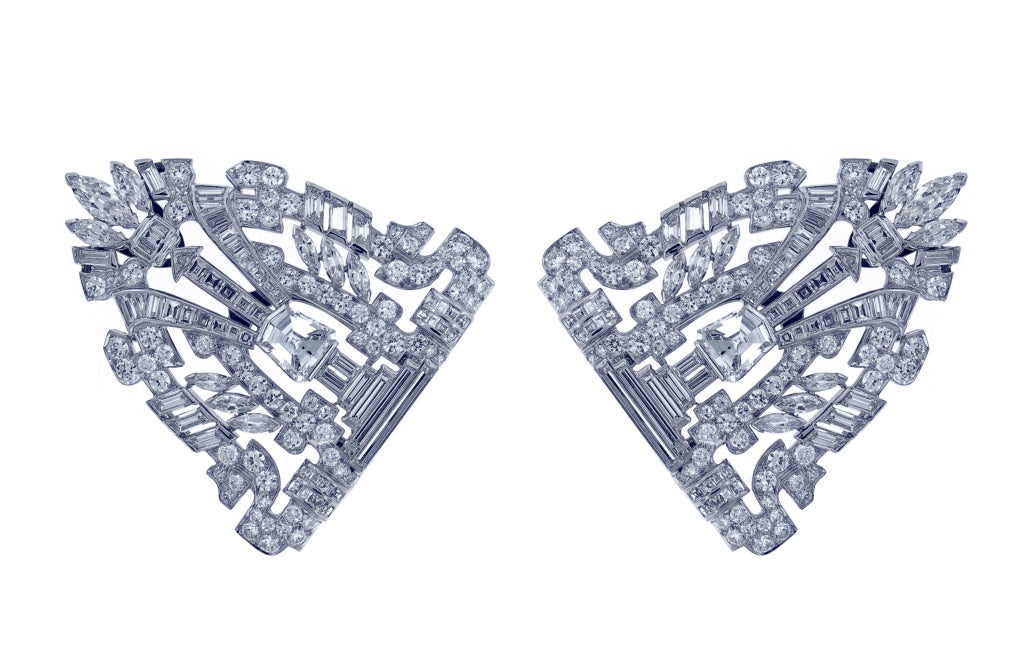 A fine example of Art Deco jewelry this brooch exemplifies the geometric design and new diamond cutting styles of the 1920s. These combination clips feature to unusual fancy cut diamond weighing a carat each an additional eleven carats of fancy cut