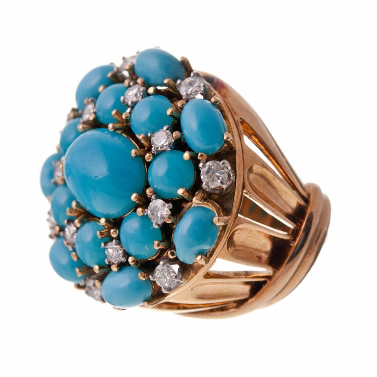 Fantastic 1950s classic cluster ring with bright turquoise cabochons set in 18k yellow gold. The turquoise is complimented by fifteen single cut diamonds peppered about to add some sparkle and an additional dimension to this playful design. The
