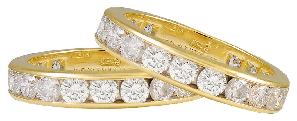 Outstanding pair of diamond eternity rings, made and signed by Tiffany & Co.  Large juicy brilliant stones totaling 6 cts., set in 18k yellow gold. 
Size 6 1/2.
These are exceptional in size and quality. They are three times larger than most