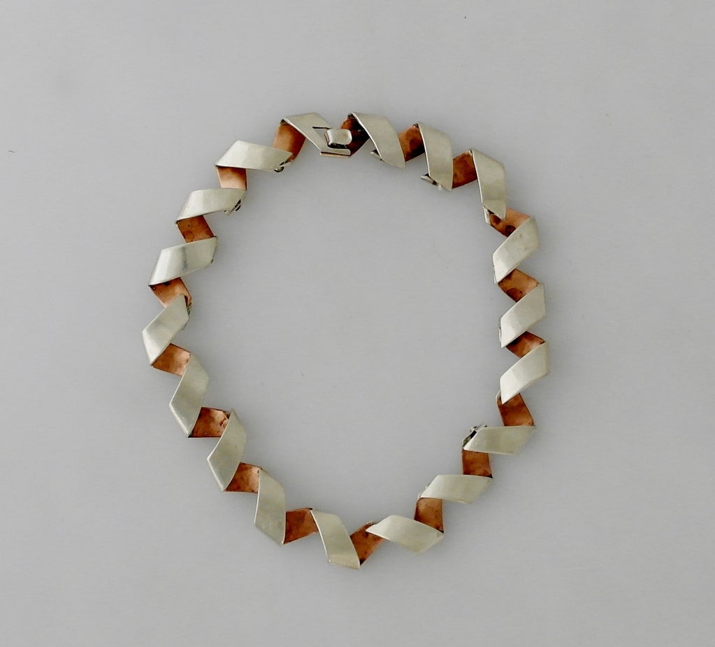 Being offered is a rare circa 1958 .970 silver and copper necklace by Antonio Pineda of Taxco, Mexico, in a bold and cutting edge ribbon motif.  Length 14 inches.  Weight 88 grams.  Marked as illustrated.  In excellent condition.

This piece of