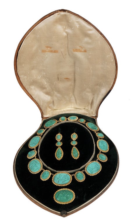 The necklace comprising a series of graduated oval malachite cameos depicting allegorical scenes, between smaller cameos of classical God's heads, each within gold cannetille work surrounds, accompanied by a brooch and pendent earrings en suite,