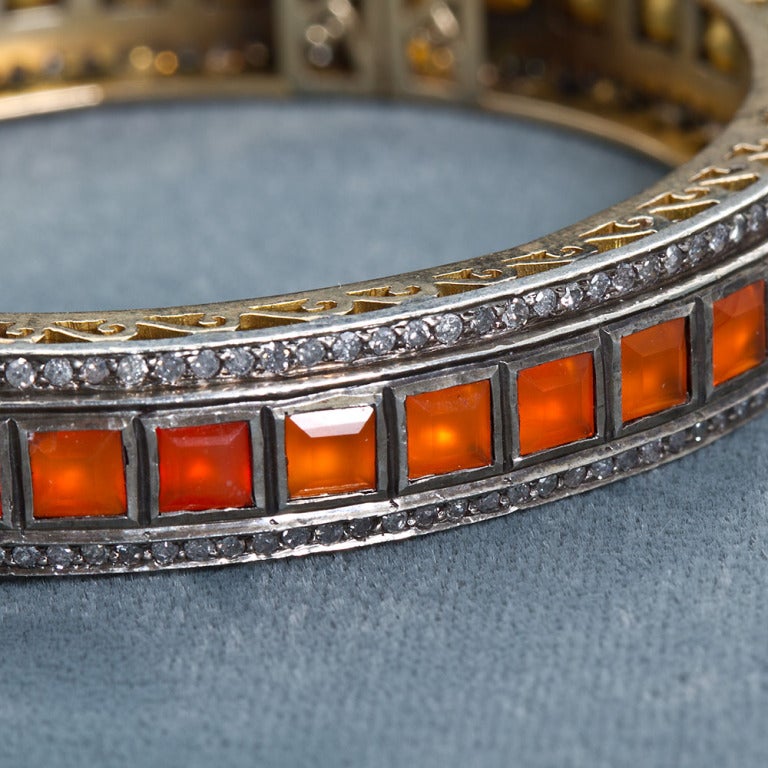 Lorraine Schwartz 18k gold fire opal and diamond antique bangle. Contains approximately 2.40 carats of diamond and 39 square faceted opals.
Measures 2-7/8