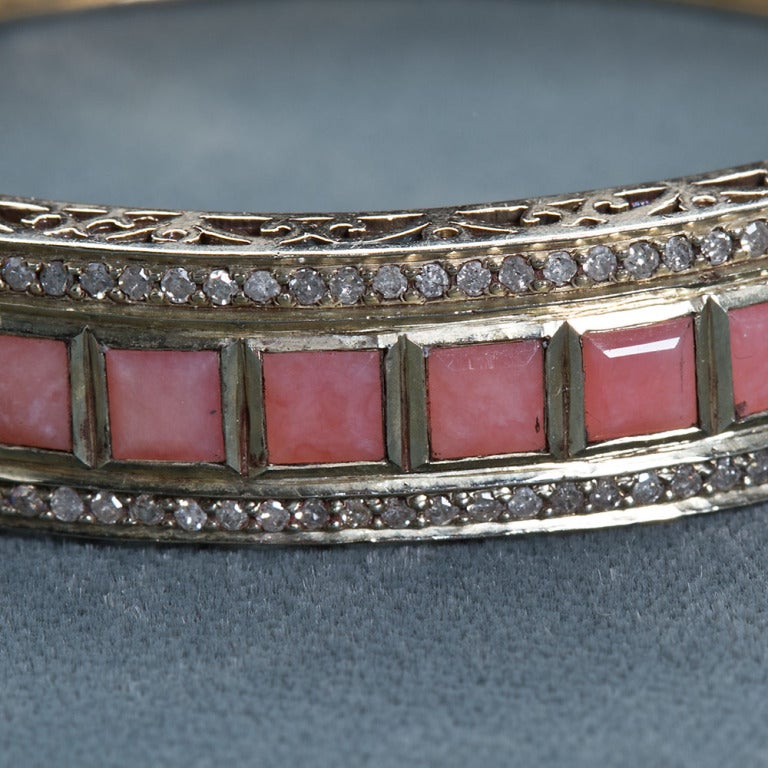 Lorraine Schwartz 18k gold pink opal and diamond antique bangle. Contains approximately 2.40 carats of diamond and 39 square faceted opals.
Measures 2-7/8