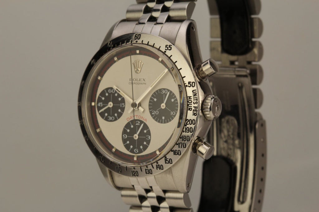 This is a beautiful example of the stainless steel Rolex Daytona Paul Newman wristwatch from the 1960s. It is a reference 6239 with a stainless tachymeter bezel and a three color original white dial. The case dial and movement are in excellent