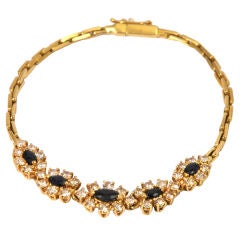 A yellow gold bracelet set with sapphires and diamonds