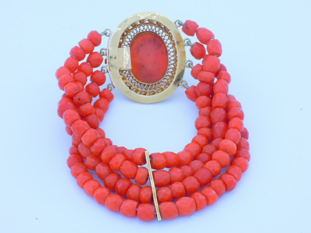 Bracelet of 4 strands of coral pearl facetts  The clasp consists of sculpted coral  cmé beautifully mounted in18k gold.