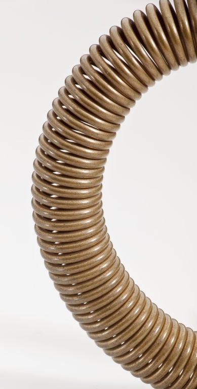 A coiled bronze bracelet by master American sculptor, Harry Bertoia (1915-1978).  With his incomparable craftmanship, Bertoia constructed this bracelet with no beginning and no end.  It slips over the wrist with ease and rests there all day.