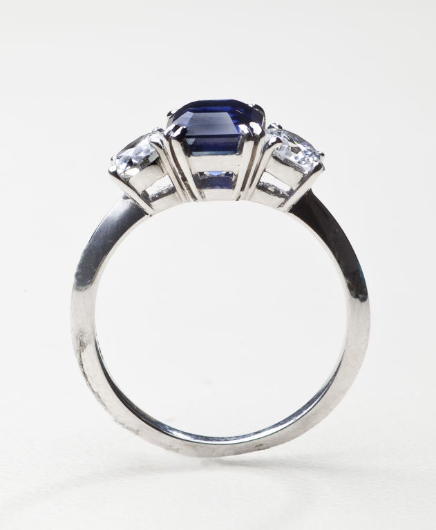 A classic diamond and sapphire ring by Tiffany & Co., approximately size 6 1/2.  The platinum setting is impressed with a 1.25 carat faceted sapphire and two .80 carat full cut, VS diamonds of G-H color.  Hallmarked Tiffany & Co.
