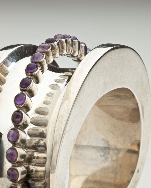 The surface of the cuff is concave with a suspended arch of cabochon amethysts. Signed with the Antonio crown mark, 970 silver, the inventory mark and the government's eagle 17 mark guaranteeing sterling content.  Fits medium size wrist.