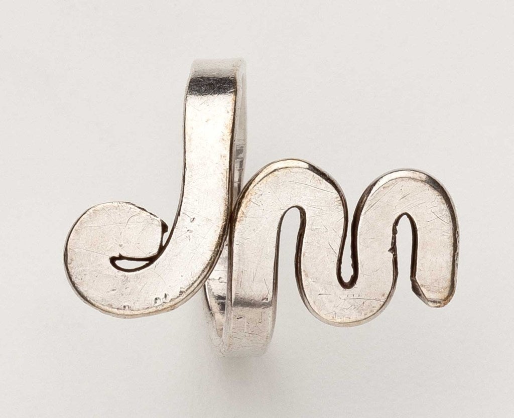 A sterling silver hand hammered ring by Alexander Calder (1898 - 1976).  This ring was executed in the form of the initials of the original owner 