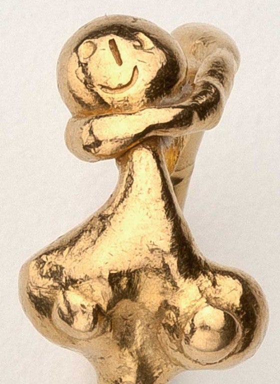 A high karat gold ring of an abstract woman's torso by the artist team of Jean-Marie and Jacline who together became Jean Mahie.  The ring is signed JM, '79 22K.   The design is whimsical and naive, showing the deliberate hand hammering of the