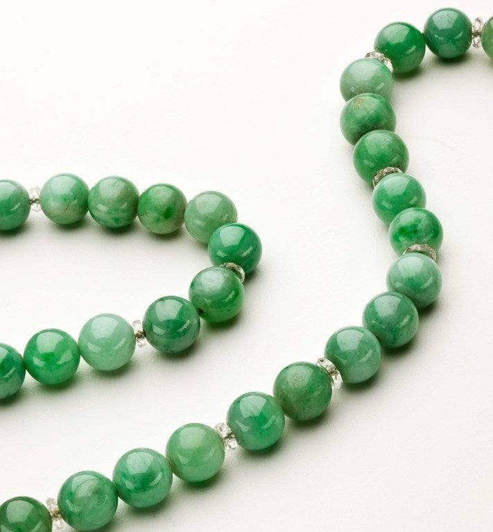 A natural jadeite necklace with 76 round 9.2mm apple green jadeite jade beads separated by faceted crystal spacers.  A 14 karat gold clasp with mine cut diamonds highlights the necklace.  The necklace comes with a Mason-Kay certificate stating that