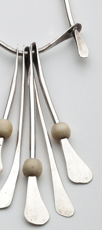A hand hammered silver and ivory pendant from Harry Bertoia's (1915-1978) Cranbrook period.  This early example shows not only the influence of modern abstraction, but of African sculpture.  The wish bone is braced by a lintel that moves up and down