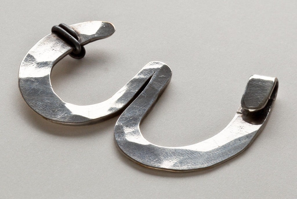 A sterling silver brooch by American pre-eminent sculptor, Alexander Calder (1898 - 1976)  Calder, who loved to make jewelry for friends and family, designed this hand hammered horse shoe shaped brooch for his friend Winifred McCulloch in 1962.  
