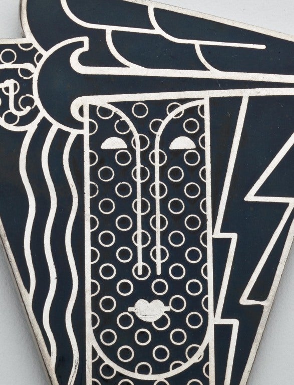 A pendant/brooch by pop artist Roy Lichtenstein in black enamel and silver on metal.  This pendant/brooch was designed by Lichtenstein in 1968 for Multiples, Inc., a gallery on Madison Avenue in New York City.  He did two versions; one in