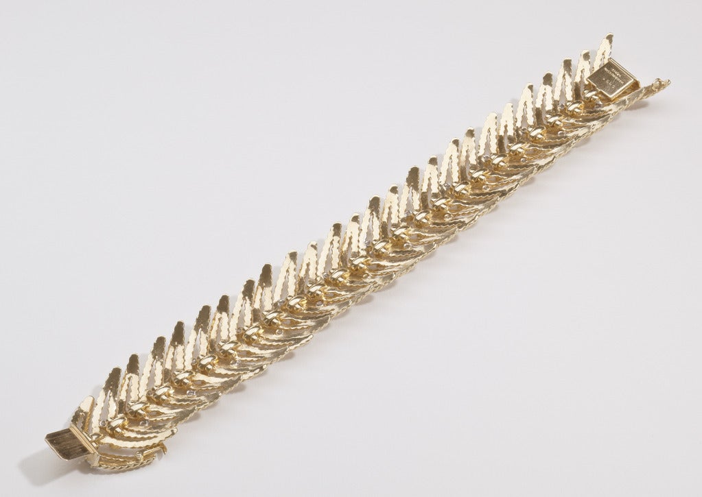 A classic link bracelet by Mauboussin in 18 karat gold and diamonds.  The rope twist interlocking links are accentuated by interspersed 26 round brilliant cut diamonds.  The diamonds are H to I color, VS - SI clarity and total 2.50 carats.  The