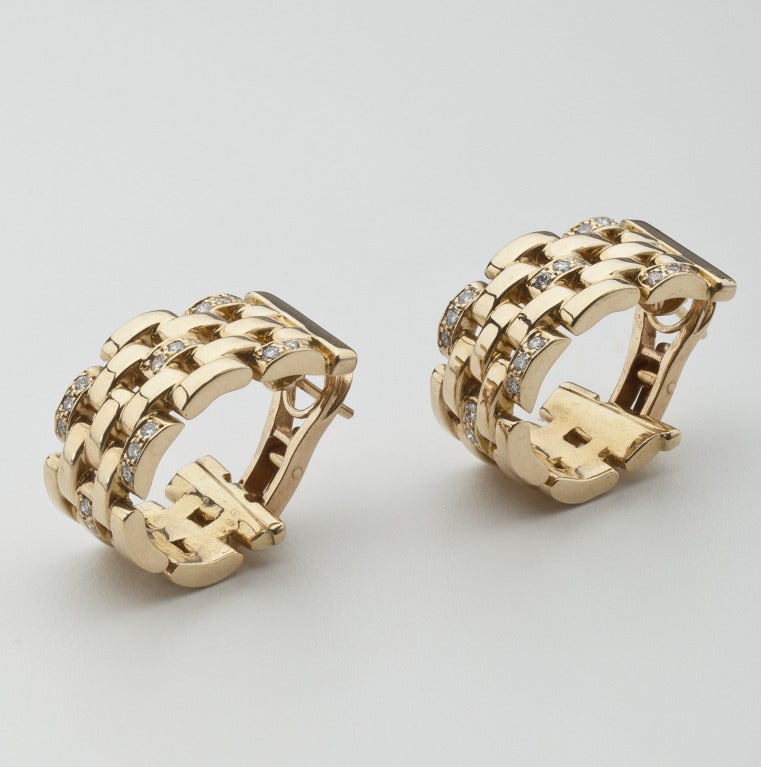 A pair of 18 karat gold earrings in a lattice work pattern and studded with full cut diamonds.  The diamonds, which number 18 on each earring, are G-F color and between the two earrings have a total weight of one carat.  Signed Cartier, B64891 with